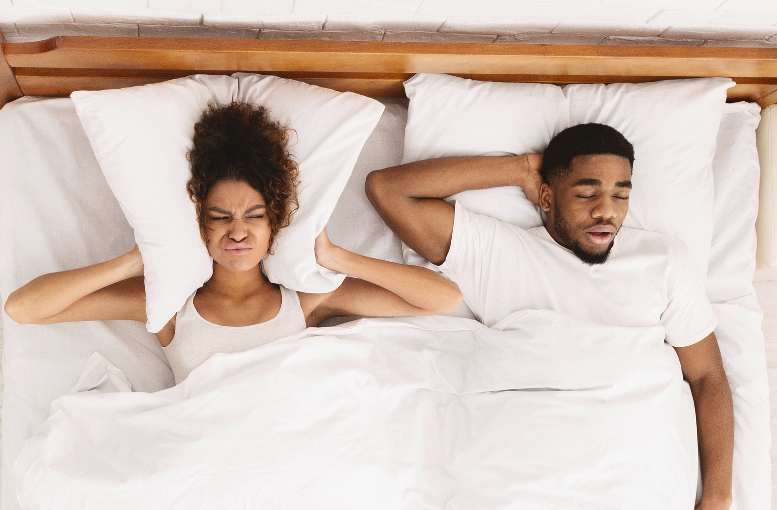Man suffering from sleep apnea by snoring and keeping his loved one awake