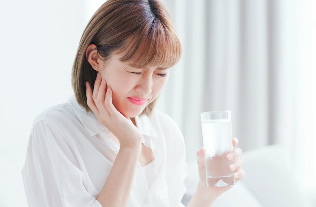 A woman drinking cold water with a cracked tooth feels pain.
