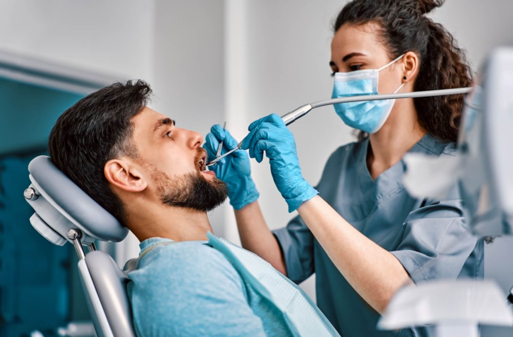 A dental hygienist uses a scaler to remove a patient's plaque, debris, and tartar.