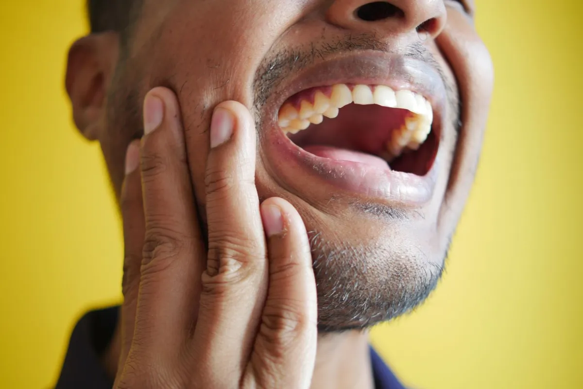 Man with severe toothache needing emergency dental care in Oakville